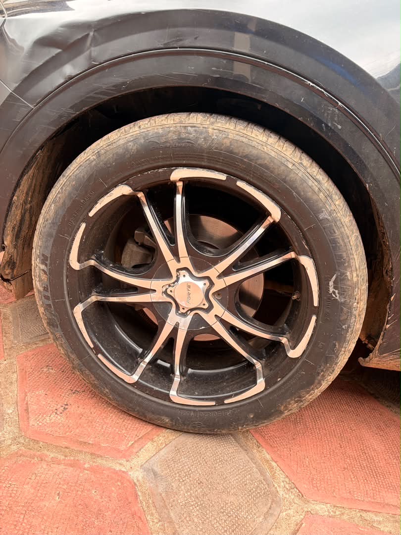 Car before wash — red laterite mud on wheel and body